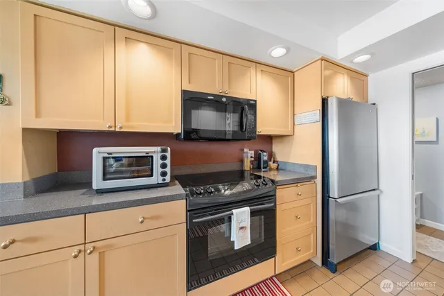 a kitchen with stainless steel appliances granite countertop a refrigerator stove and microwave