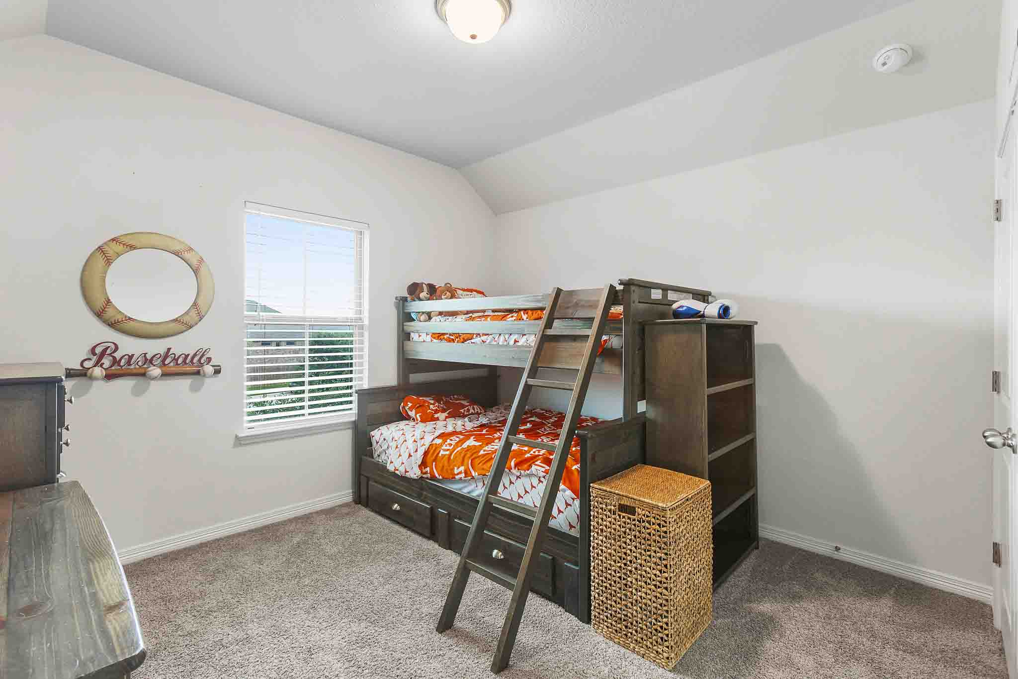166 West Branch Road Kyle, TX 78640 - Photo 27 of 39 A well-lit bedroom features plush carpet and a window for natural illumination.