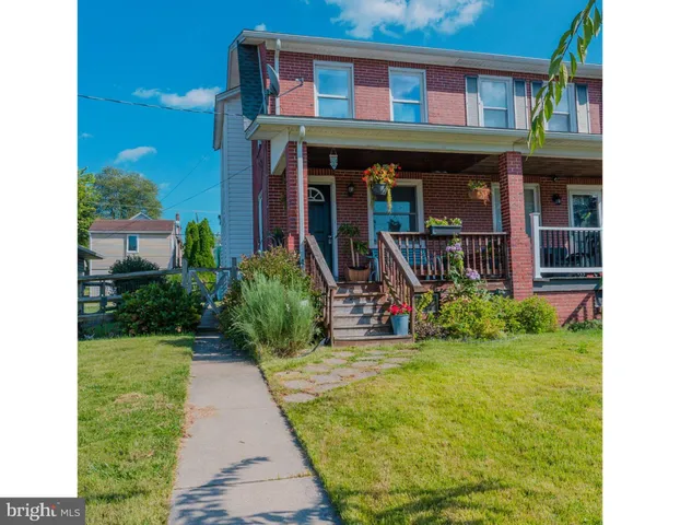 a view of a house with potted plants and a yard