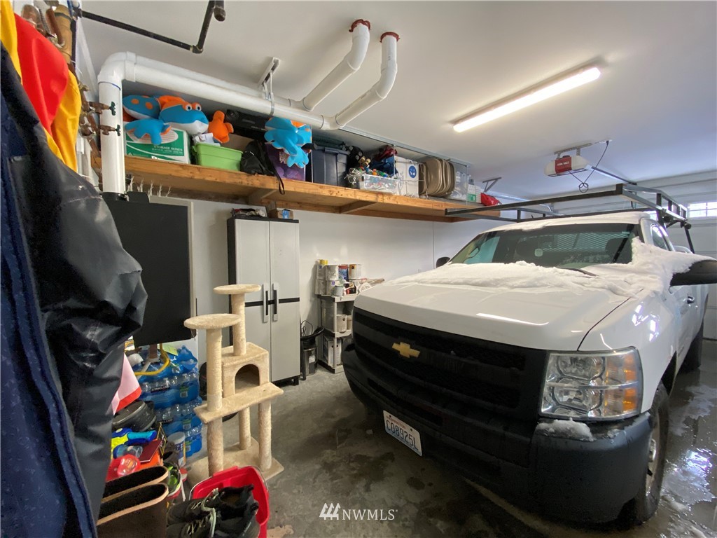 3519 McGee Road Blaine, WA 98230 - Photo 33 of 40 a utility room with stainless steel appliances lots of clutter and bicycles