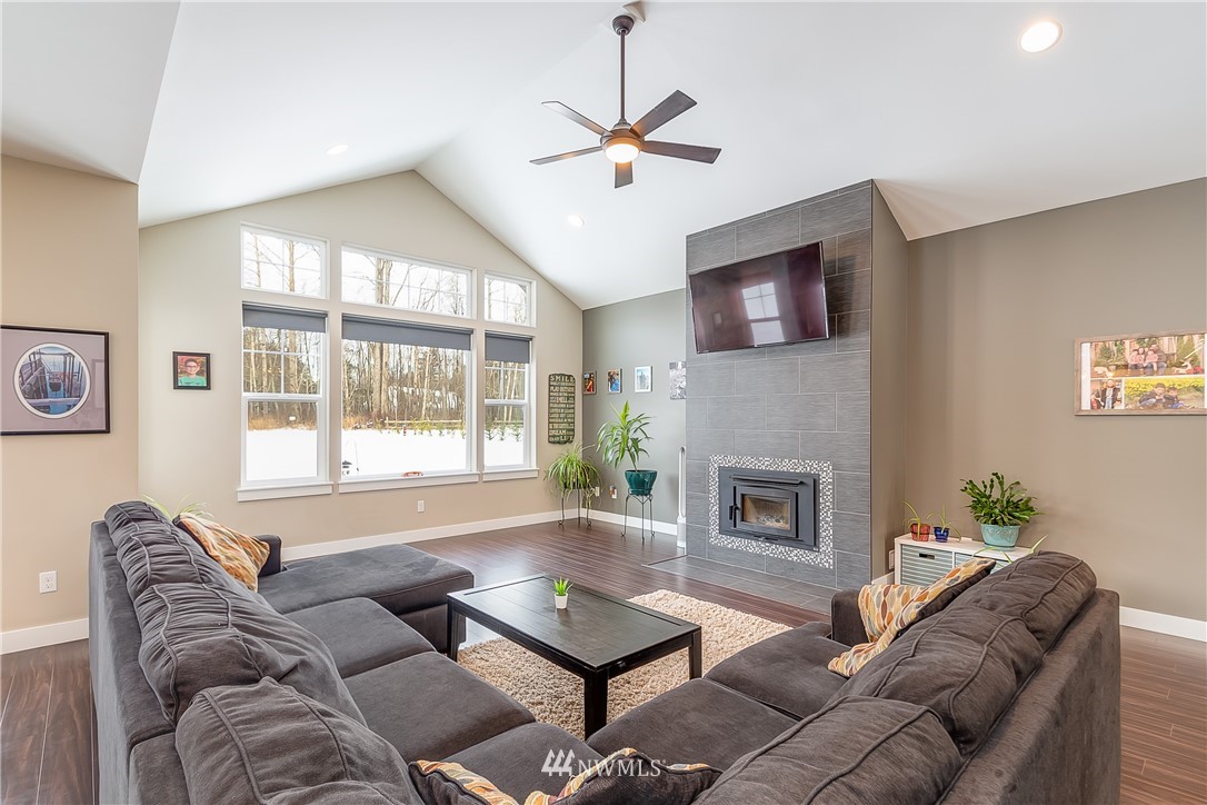 3519 McGee Road Blaine, WA 98230 - Photo 10 of 40 a living room with furniture a fireplace and a flat screen tv