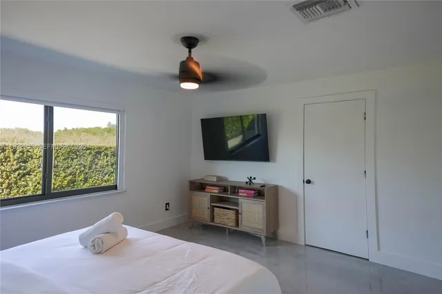 a bedroom with a bed and a flat screen tv