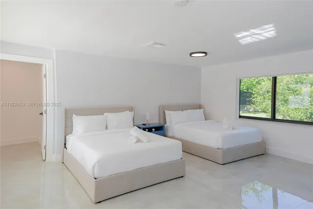 a bedroom with two beds and a large window