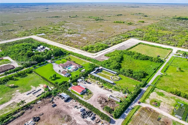 an aerial view of ocean with residential house and green space