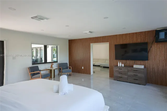 a bedroom with furniture and a flat screen tv