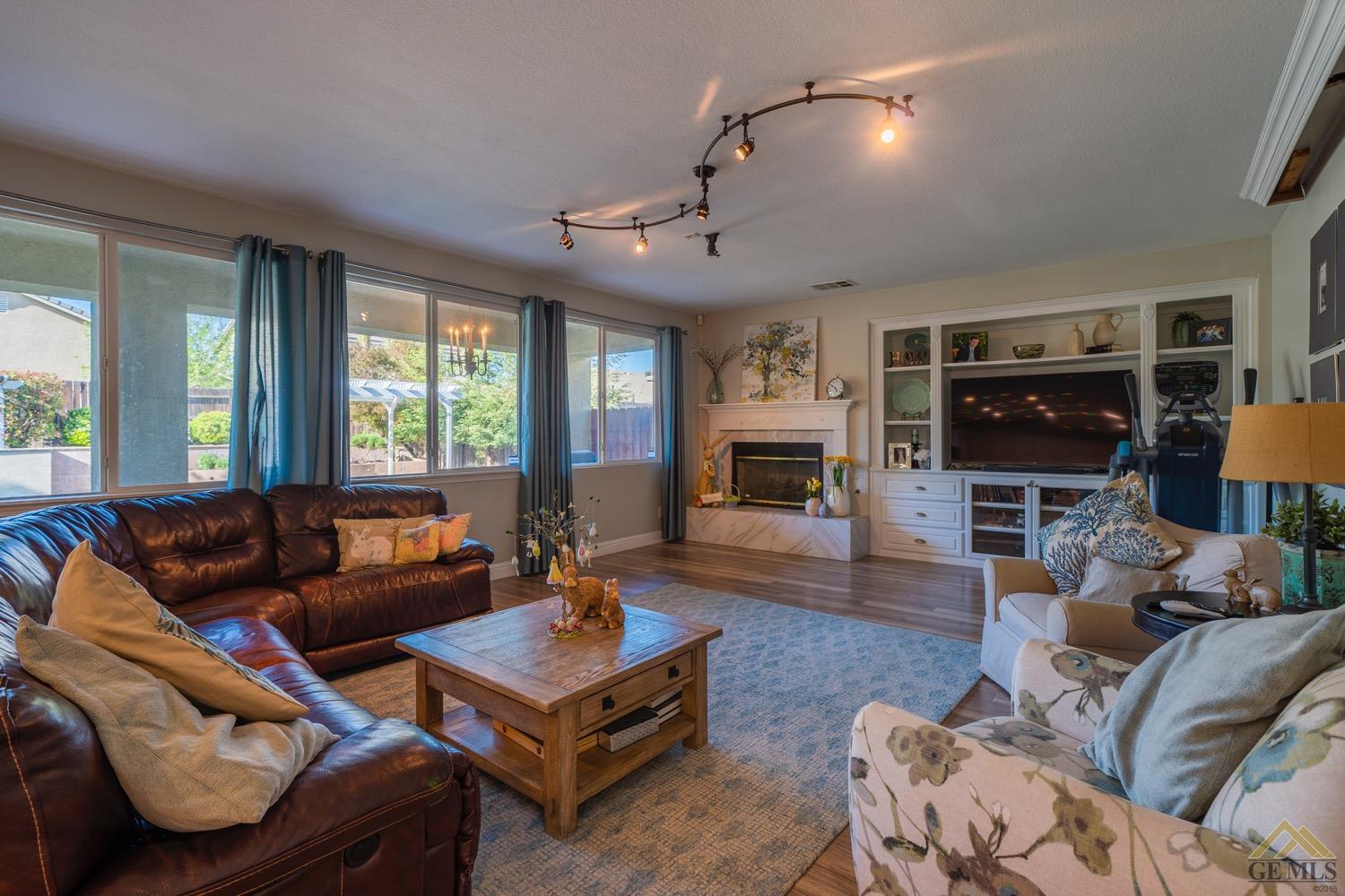 Undisclosed Address Bakersfield, CA 93312 - Photo 13 of 33 a living room with furniture ceiling fan and a fireplace