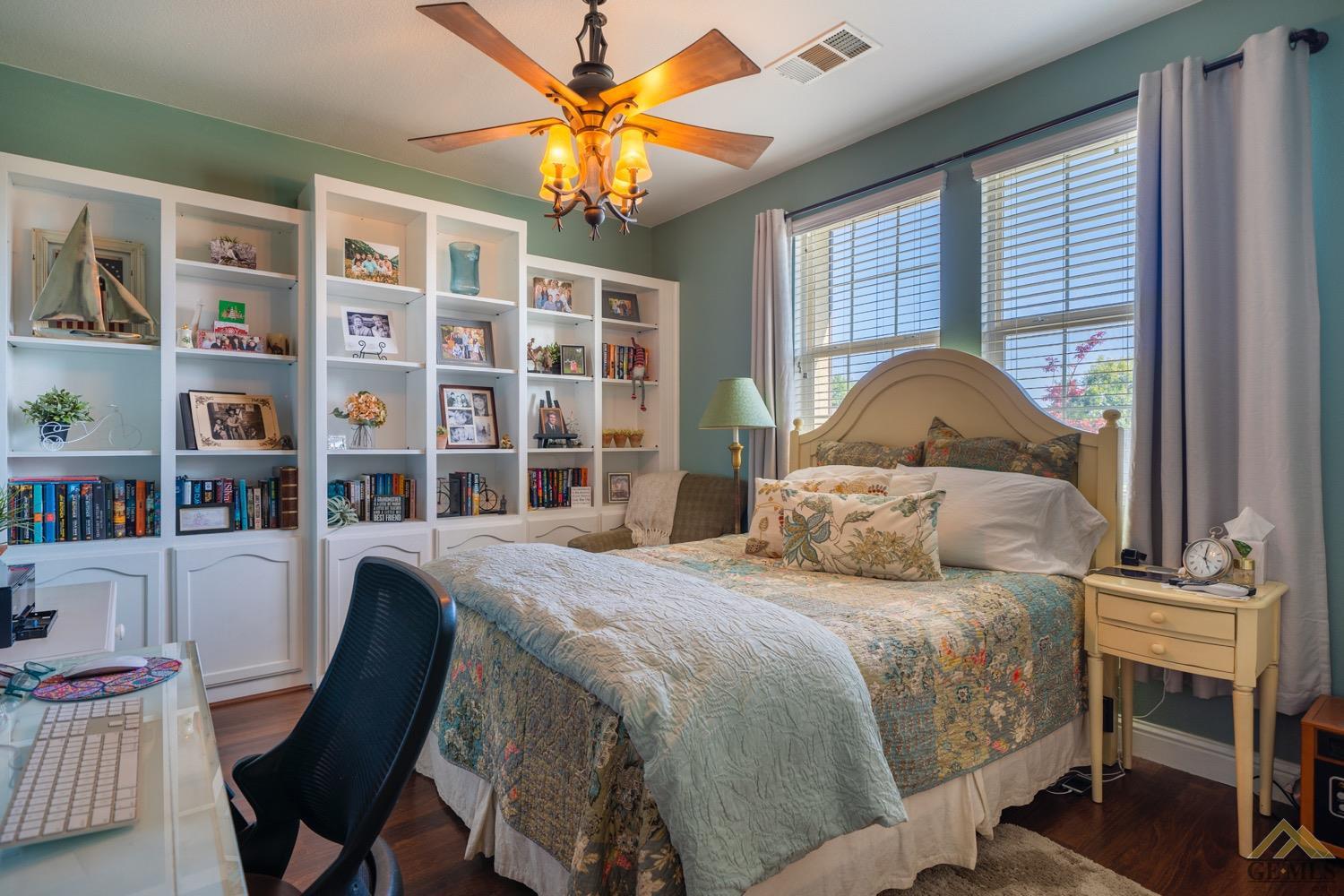 Undisclosed Address Bakersfield, CA 93312 - Photo 16 of 33 a bedroom with a large bed a table and a book shelf