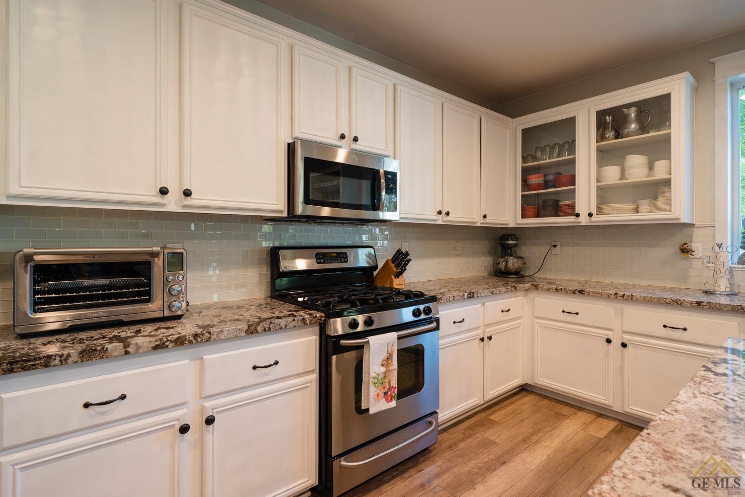 Undisclosed Address Bakersfield, CA 93312 - Photo 10 of 33 a kitchen with granite countertop white cabinets stainless steel appliances and a sink