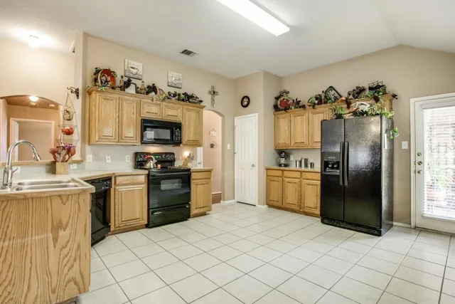 a kitchen with granite countertop a refrigerator and a stove top oven