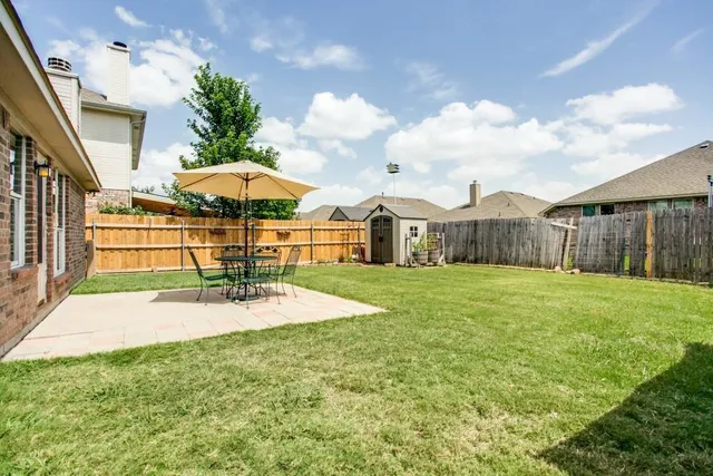 a view of a house with backyard and sitting area