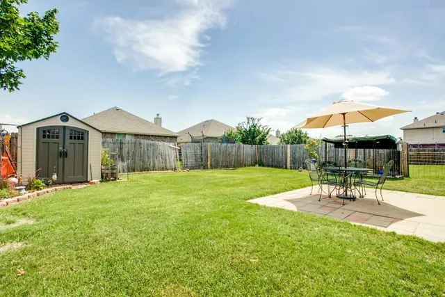 a patio with a table and chairs under an umbrella