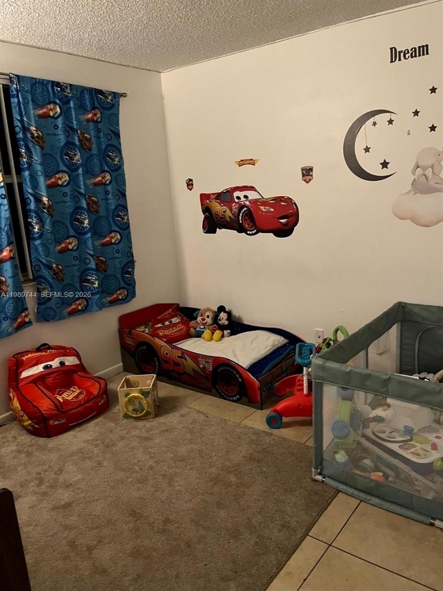 8761 Wiles Road, Unit 206 Coral Springs, FL 33067 - Photo 12 of 16 a bedroom with a bed and cabinets