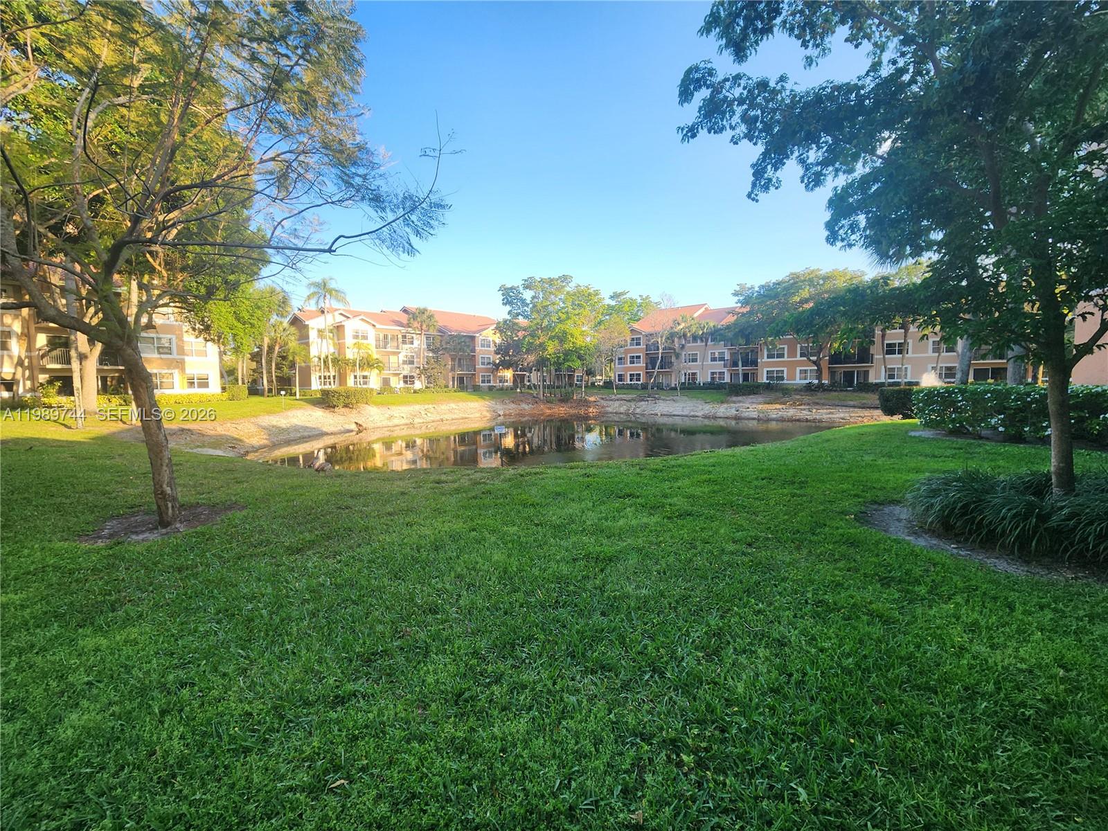 8761 Wiles Road, Unit 206 Coral Springs, FL 33067 - Photo 3 of 16 a view of a big yard with swimming pool and green space