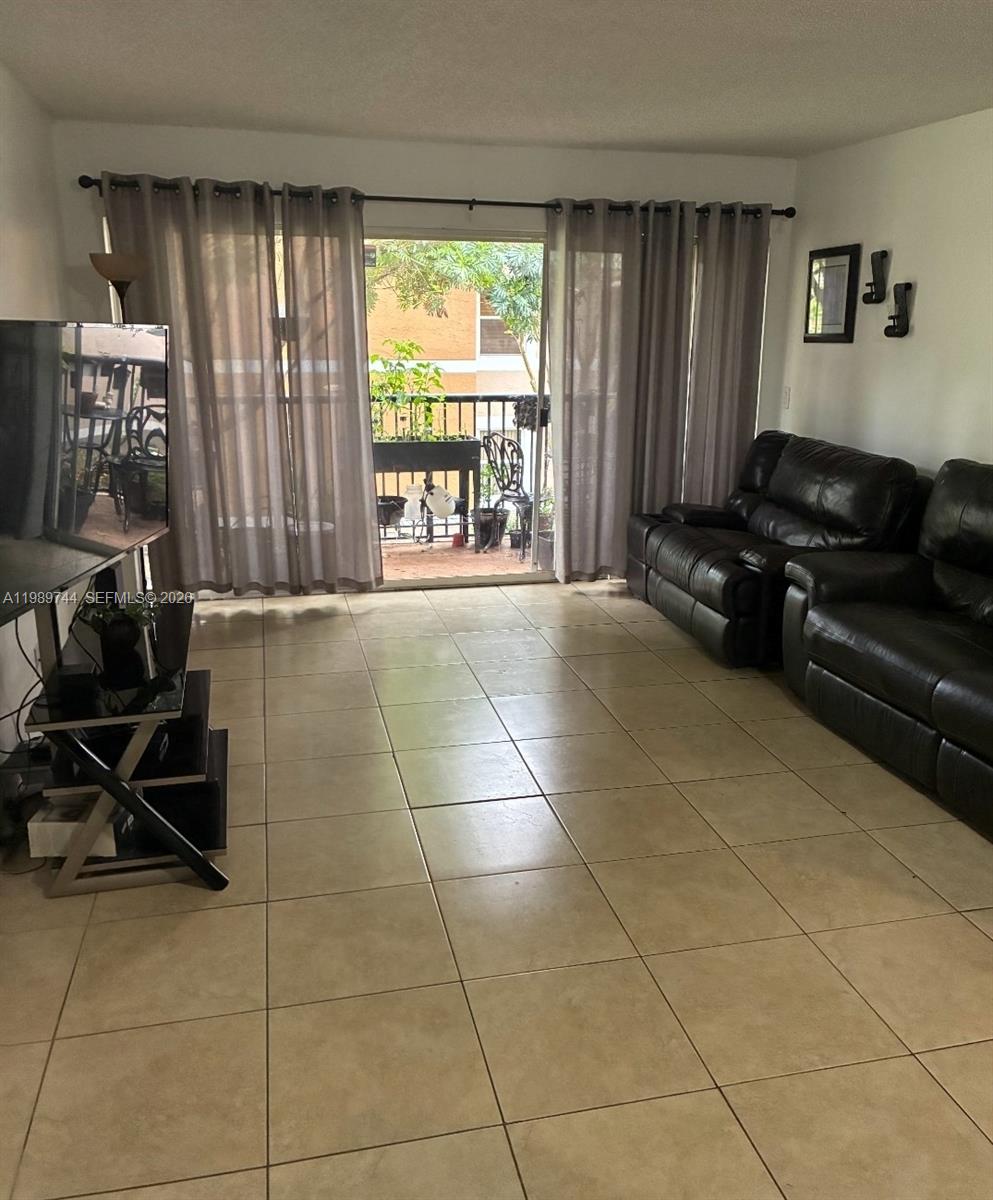 8761 Wiles Road, Unit 206 Coral Springs, FL 33067 - Photo 7 of 16 a living room with furniture and a floor to ceiling window