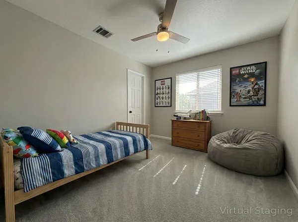 an empty room with windows and chandelier fan
