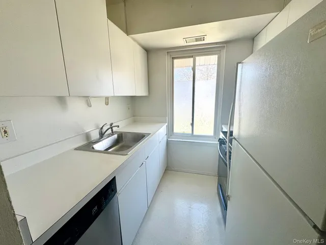 a kitchen with a sink cabinets and a window
