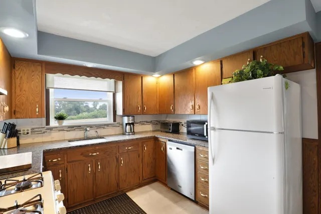 a kitchen with a refrigerator a sink and a stove top oven