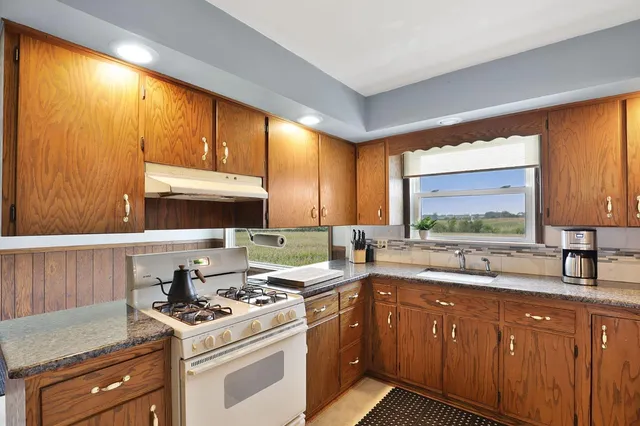 a kitchen with a sink stove top oven and cabinets