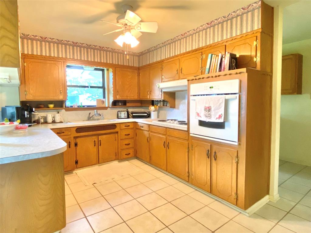 1605 Tolar Cemetery Road Tolar, TX 76476 - Photo 16 of 25 a kitchen with a sink a stove and cabinets