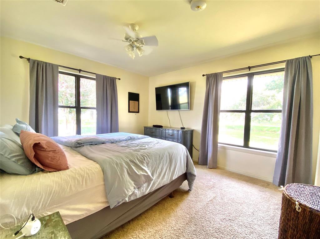 1605 Tolar Cemetery Road Tolar, TX 76476 - Photo 19 of 25 a bedroom with a bed and a flat tv screen on dresser