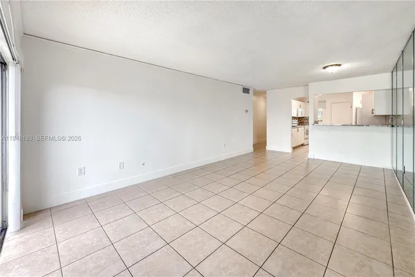 a view of a kitchen with a sink and an empty room