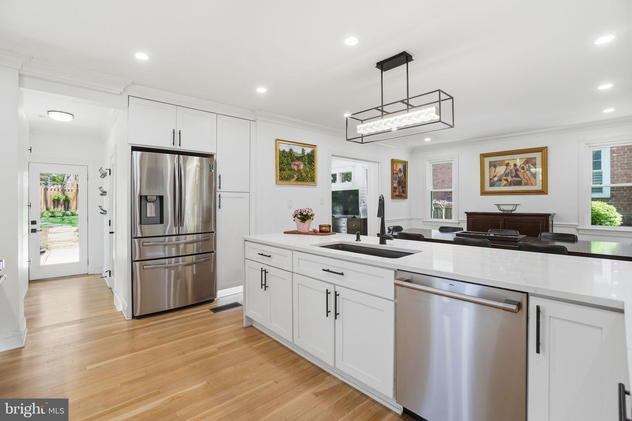 3327 Legation Street Northwest Washington, DC 20015 - Photo 13 of 36 a kitchen with stainless steel appliances wooden floor and a refrigerator