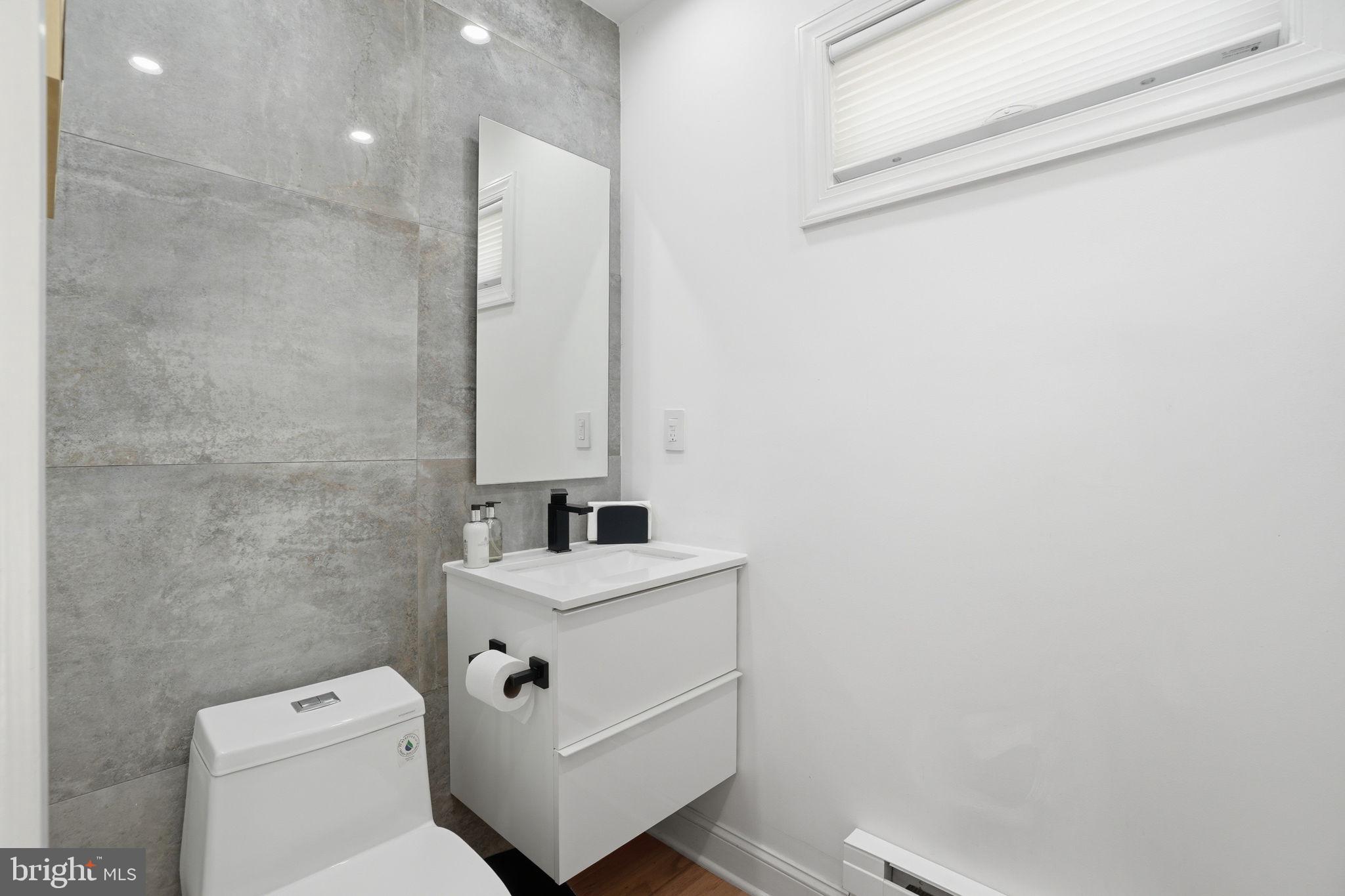 3327 Legation Street Northwest Washington, DC 20015 - Photo 16 of 36 a bathroom with a toilet sink and mirror