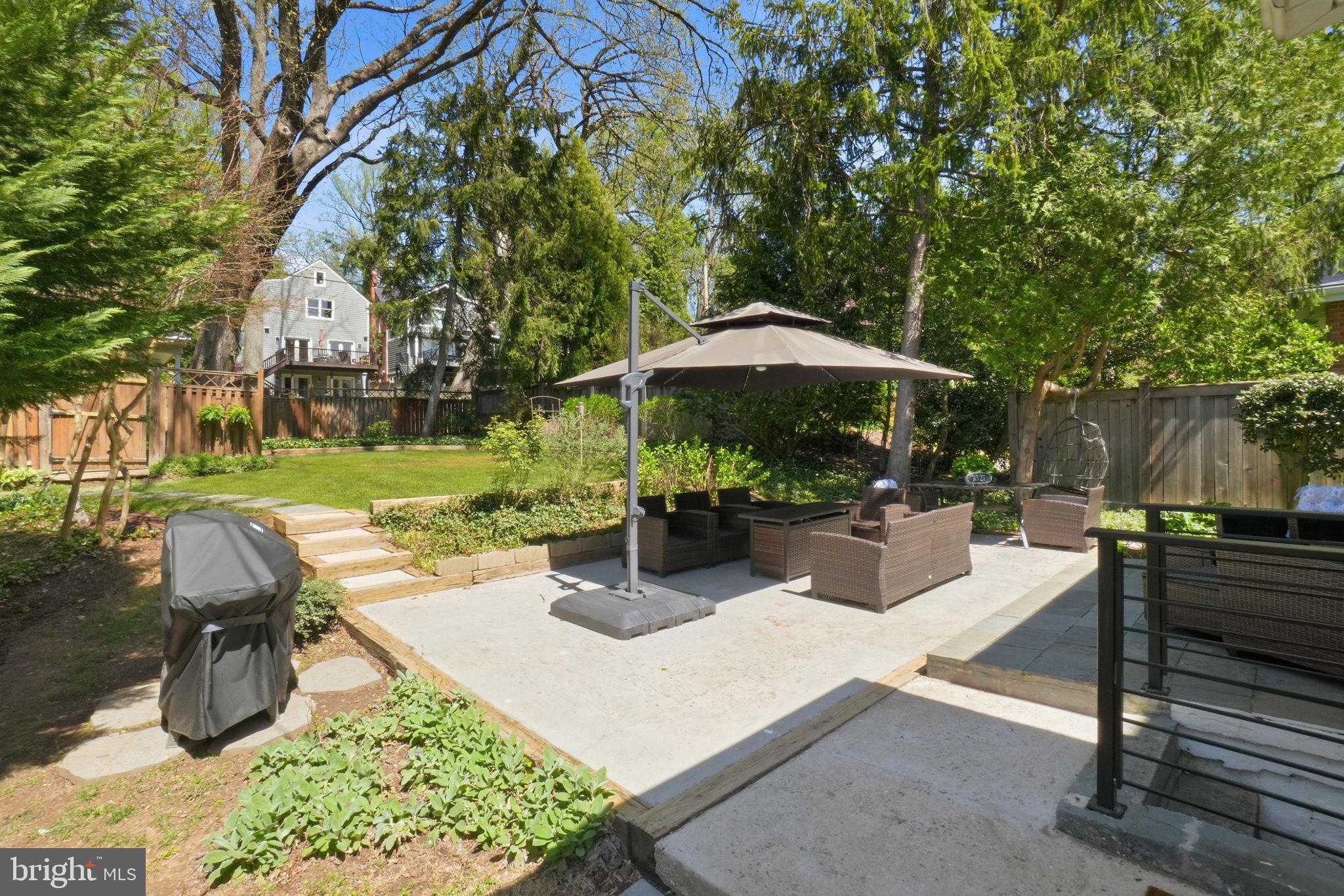 3327 Legation Street Northwest Washington, DC 20015 - Photo 34 of 36 a view of a patio with couches table and chairs under an umbrella