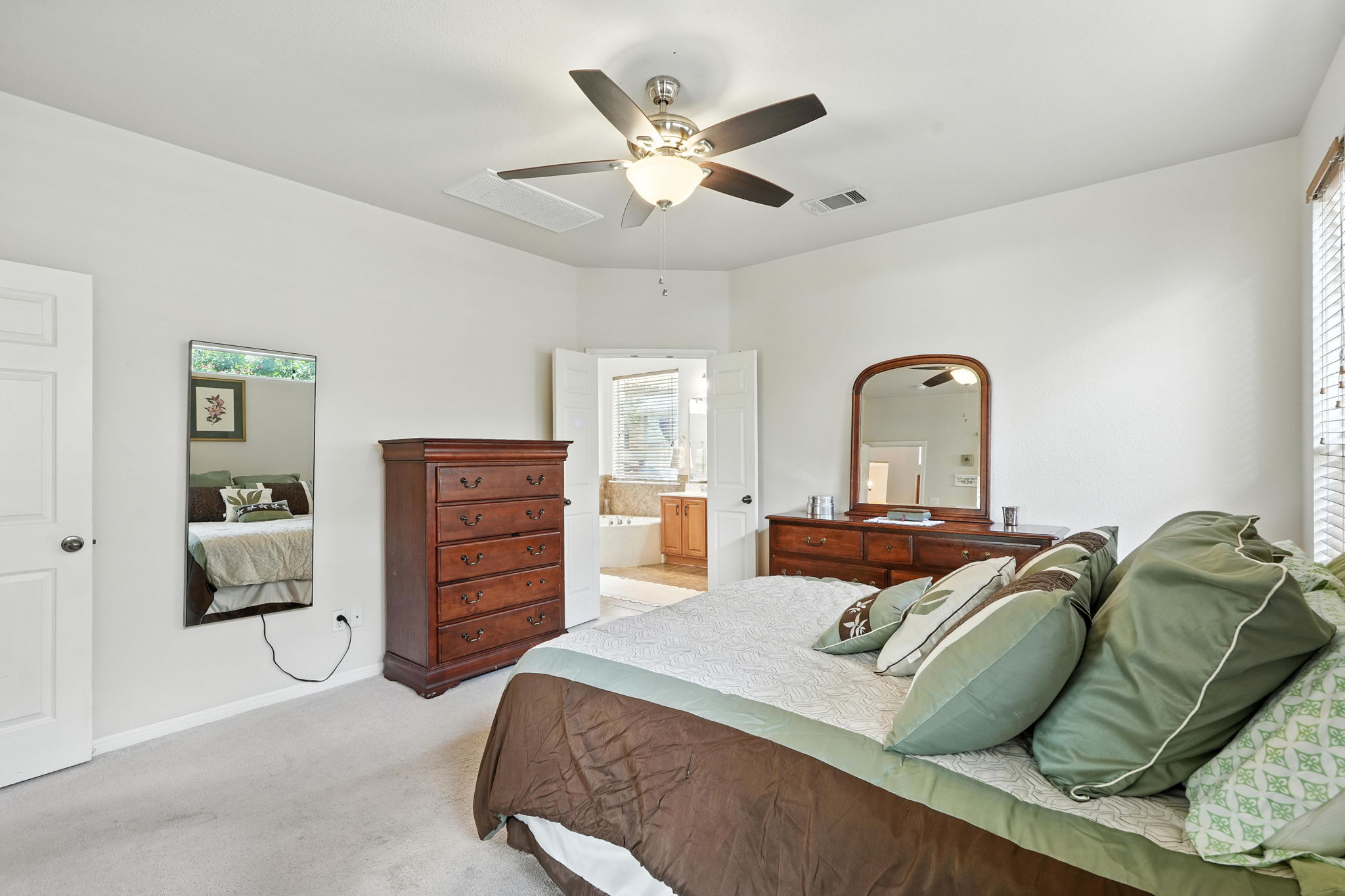 1802 Misty Ridge Leander, TX 78641 - Photo 15 of 39 Primary bedroom with light carpet, connected bathroom, a ceiling fan, and an office alcove. Located on main floor.