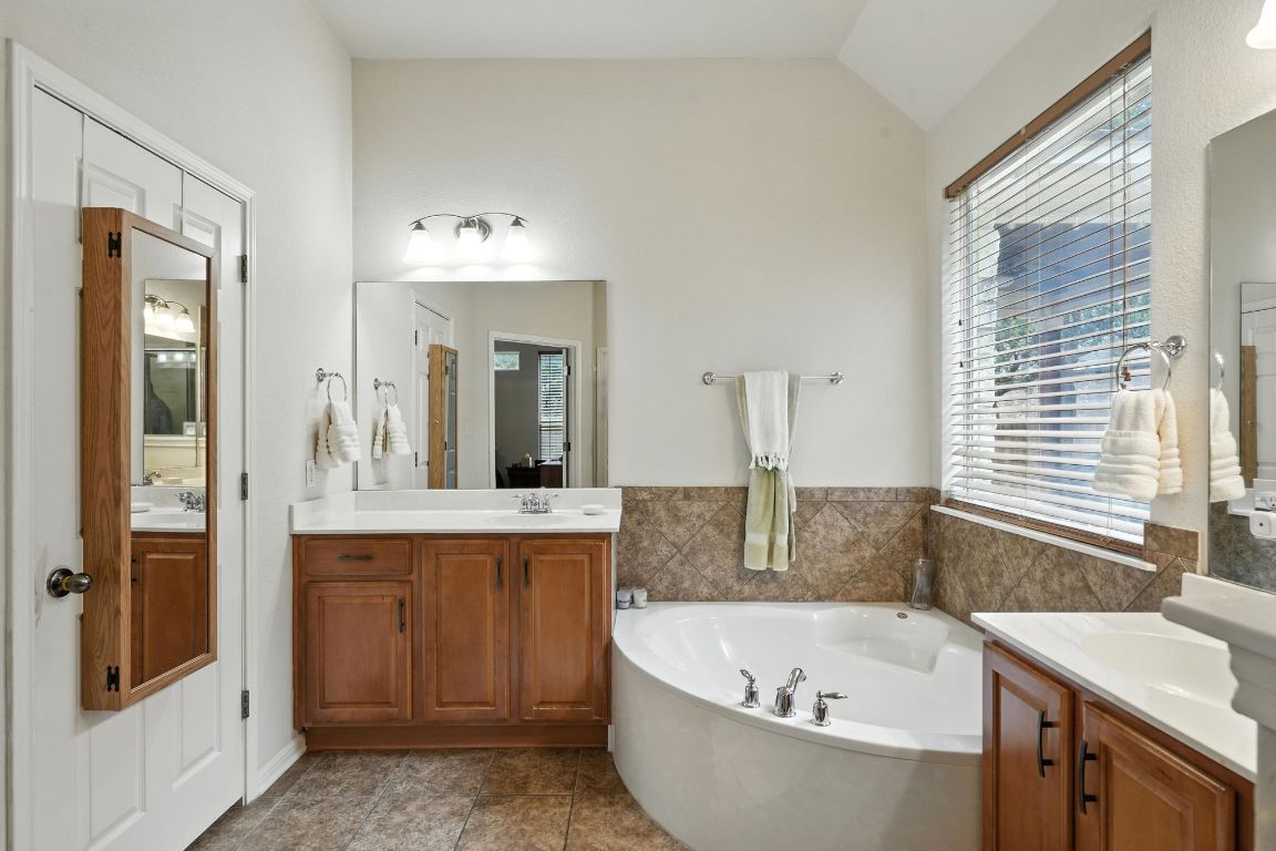 1802 Misty Ridge Leander, TX 78641 - Photo 17 of 39 a bathroom with a granite countertop tub sink and mirror
