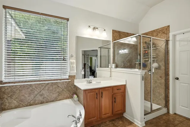 a bathroom with a tub a sink and a mirror