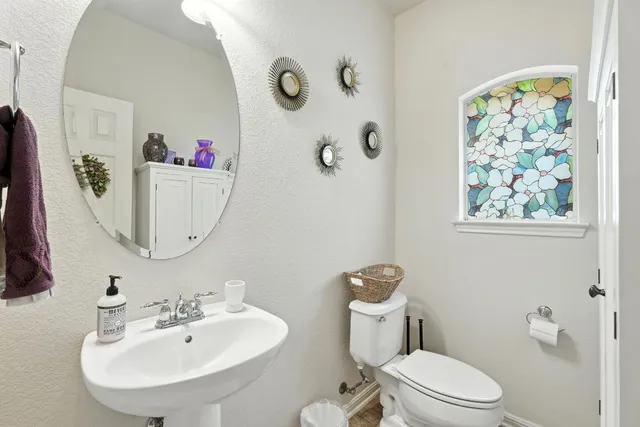 a bathroom with a toilet sink and mirror