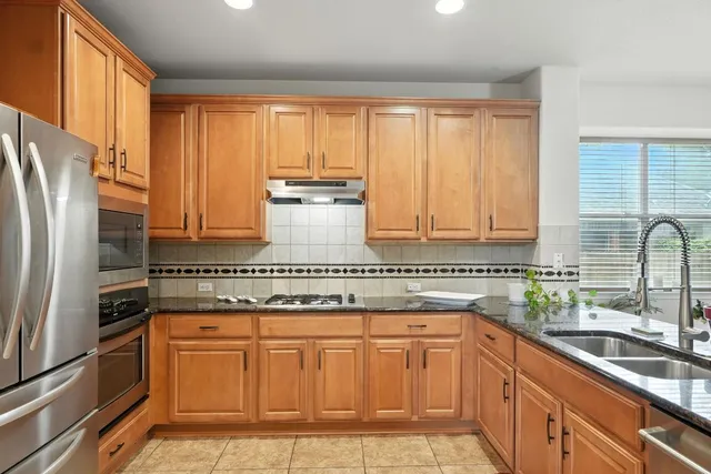 a kitchen with stainless steel appliances granite countertop a refrigerator sink and cabinets