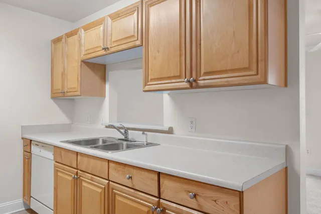 a kitchen with granite countertop white cabinets and a sink