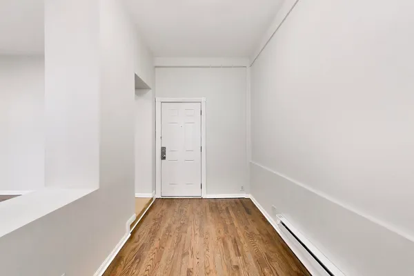 a view of a small space with wooden floor and a window
