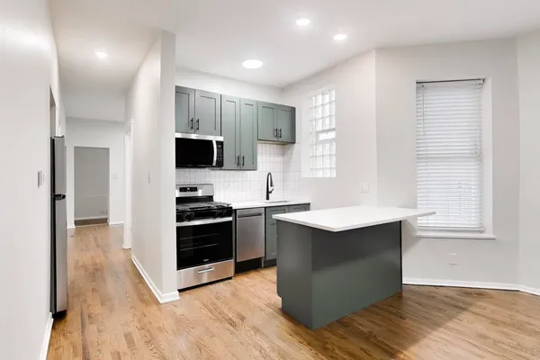 a kitchen with stainless steel appliances granite countertop a stove a sink and a refrigerator