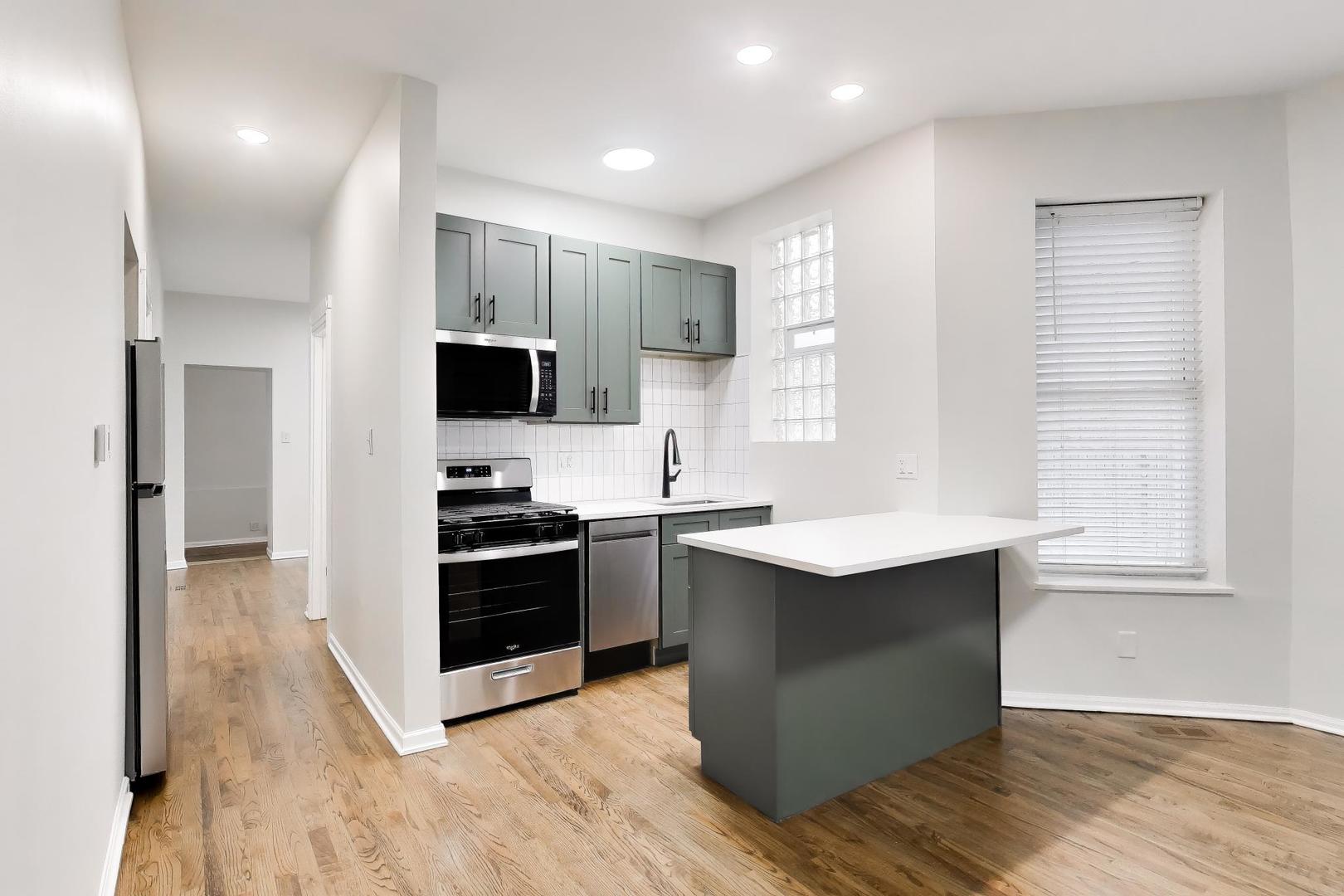 2135 West Division Street, Unit 1R Chicago, IL 60622 - Photo 3 of 12 a kitchen with stainless steel appliances granite countertop a stove a sink and a refrigerator