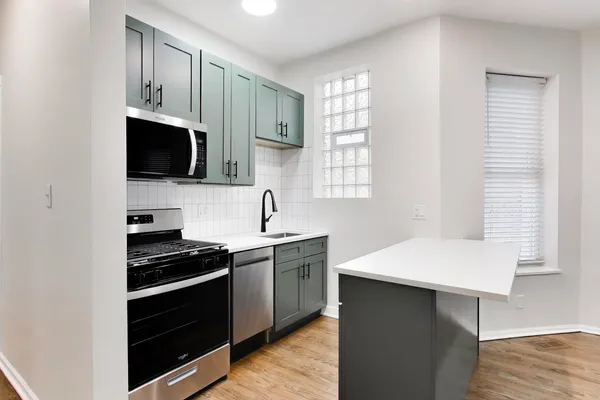 a kitchen with stainless steel appliances a stove microwave and sink