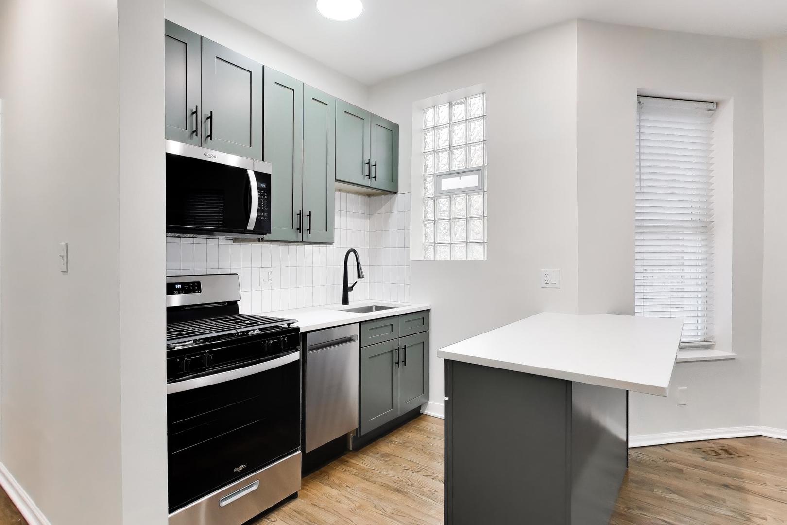 2135 West Division Street, Unit 1R Chicago, IL 60622 - Photo 4 of 12 a kitchen with stainless steel appliances a stove microwave and sink