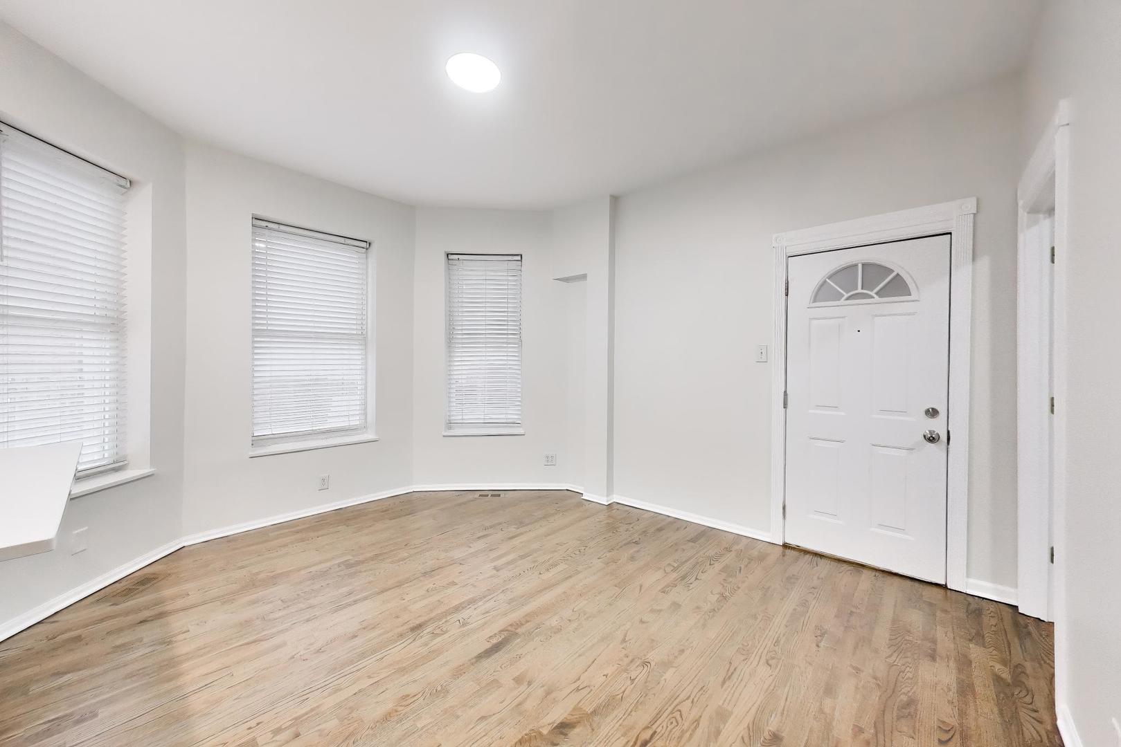 2135 West Division Street, Unit 1R Chicago, IL 60622 - Photo 5 of 12 a view of empty room with wooden floor and fan