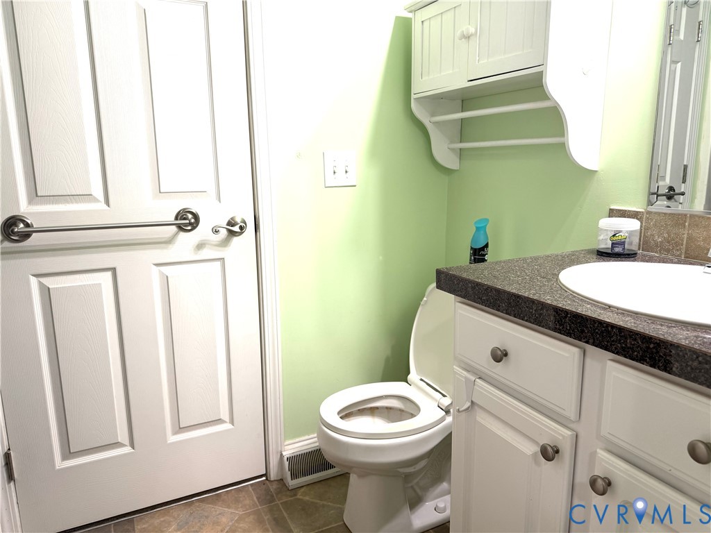 14558 Brick Road Petersburg, VA 23805 - Photo 18 of 27 Half bath featuring vanity and dark tile patterned