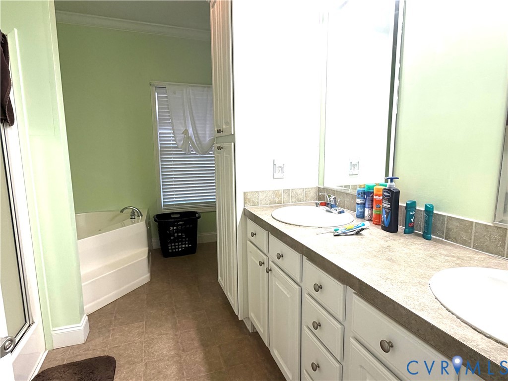 14558 Brick Road Petersburg, VA 23805 - Photo 22 of 27 Bathroom with double vanity, a bath, and crown mol