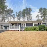 a front view of a house with a yard and potted plants