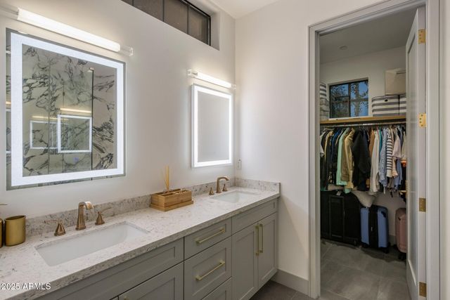 a en suite bathroom with a double vanity sink and a mirror
