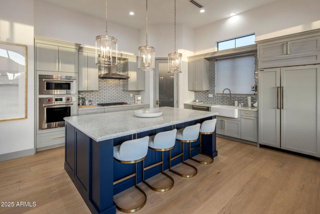 a kitchen with kitchen island a sink stove and refrigerator