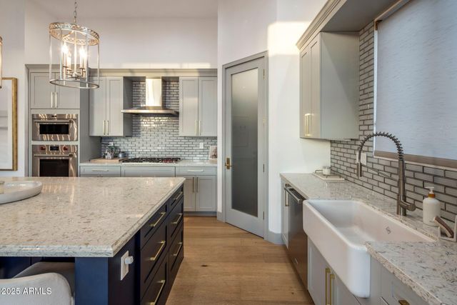 a kitchen with stainless steel appliances granite countertop a sink stove and refrigerator