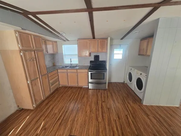 a kitchen with wooden floors and appliances