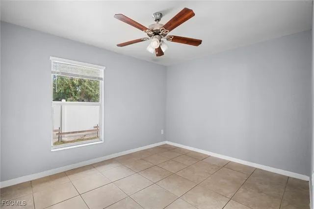 an empty room with windows and ceiling fan