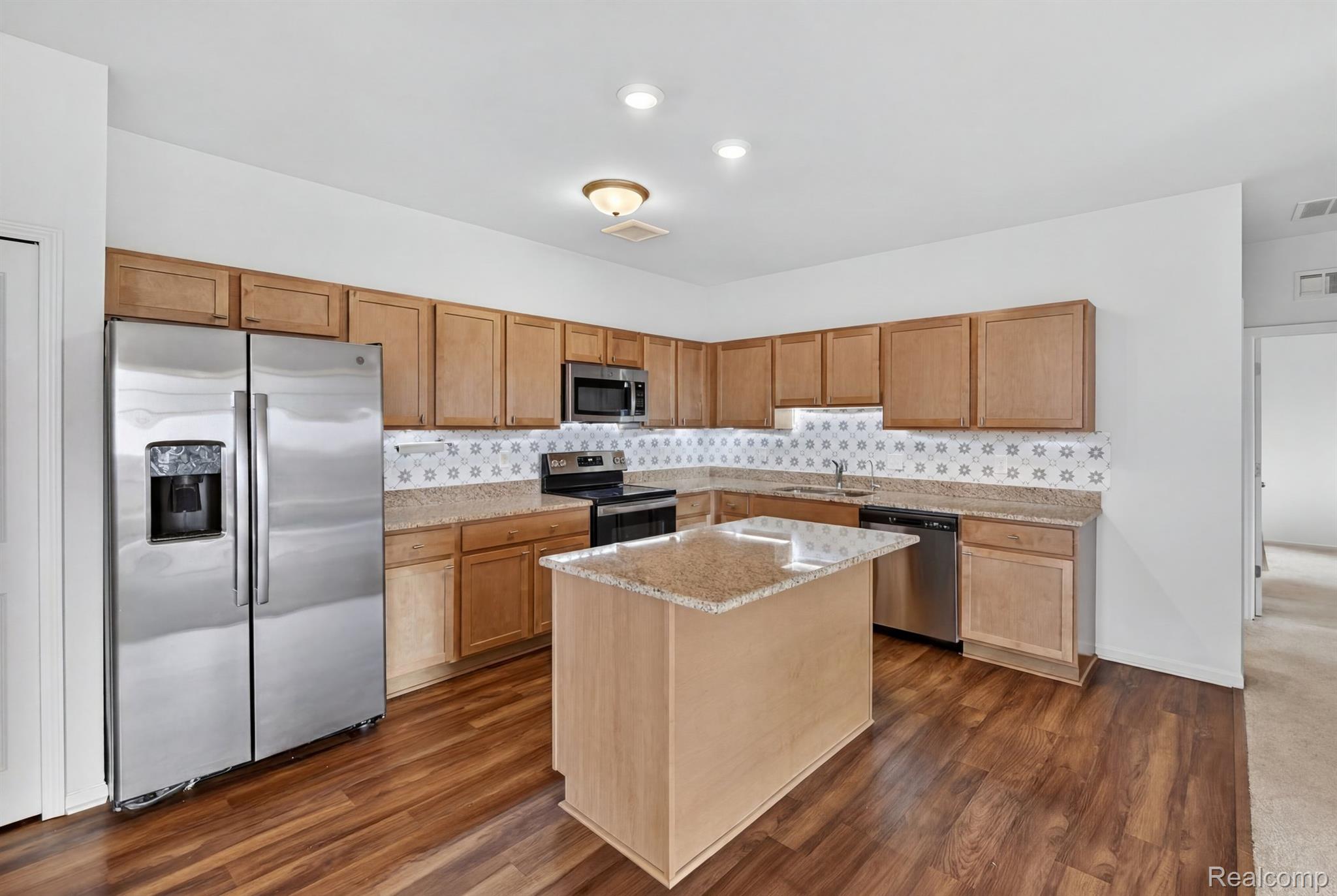 9812 Ridge Run, Unit 55 Howell, MI 48855 - Photo 5 of 23 Kitchen with island and granite countertops