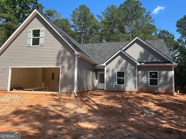 a front view of house with yard and trees in the background